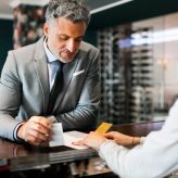 mature-businessman-at-hotel-reception-PSCUC9L